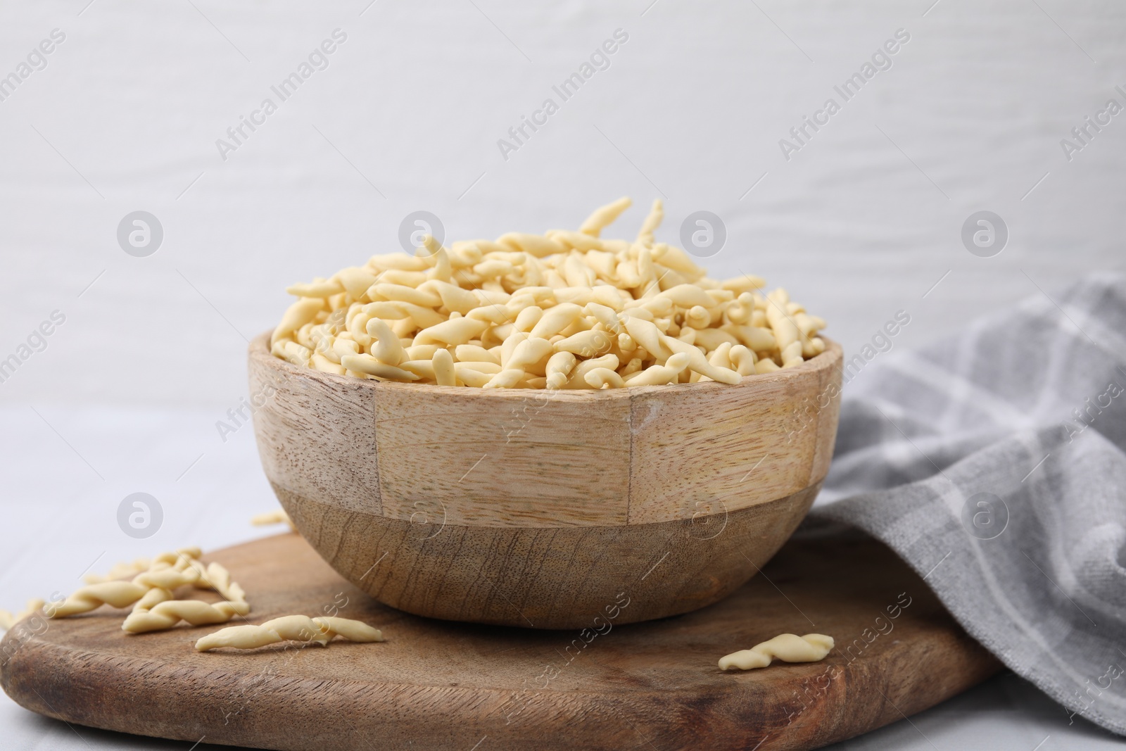Photo of Bowl with uncooked Italian trofie pasta on table