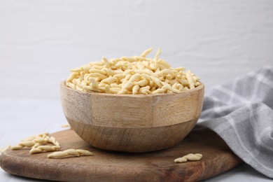 Bowl with uncooked Italian trofie pasta on table