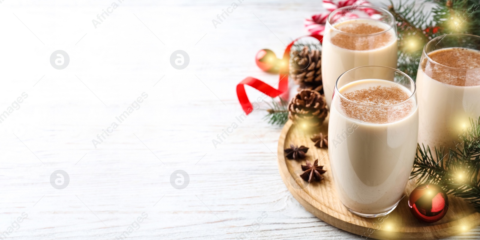 Image of Delicious Christmas cocktail with liqueur on white wooden table with space for text. Banner design