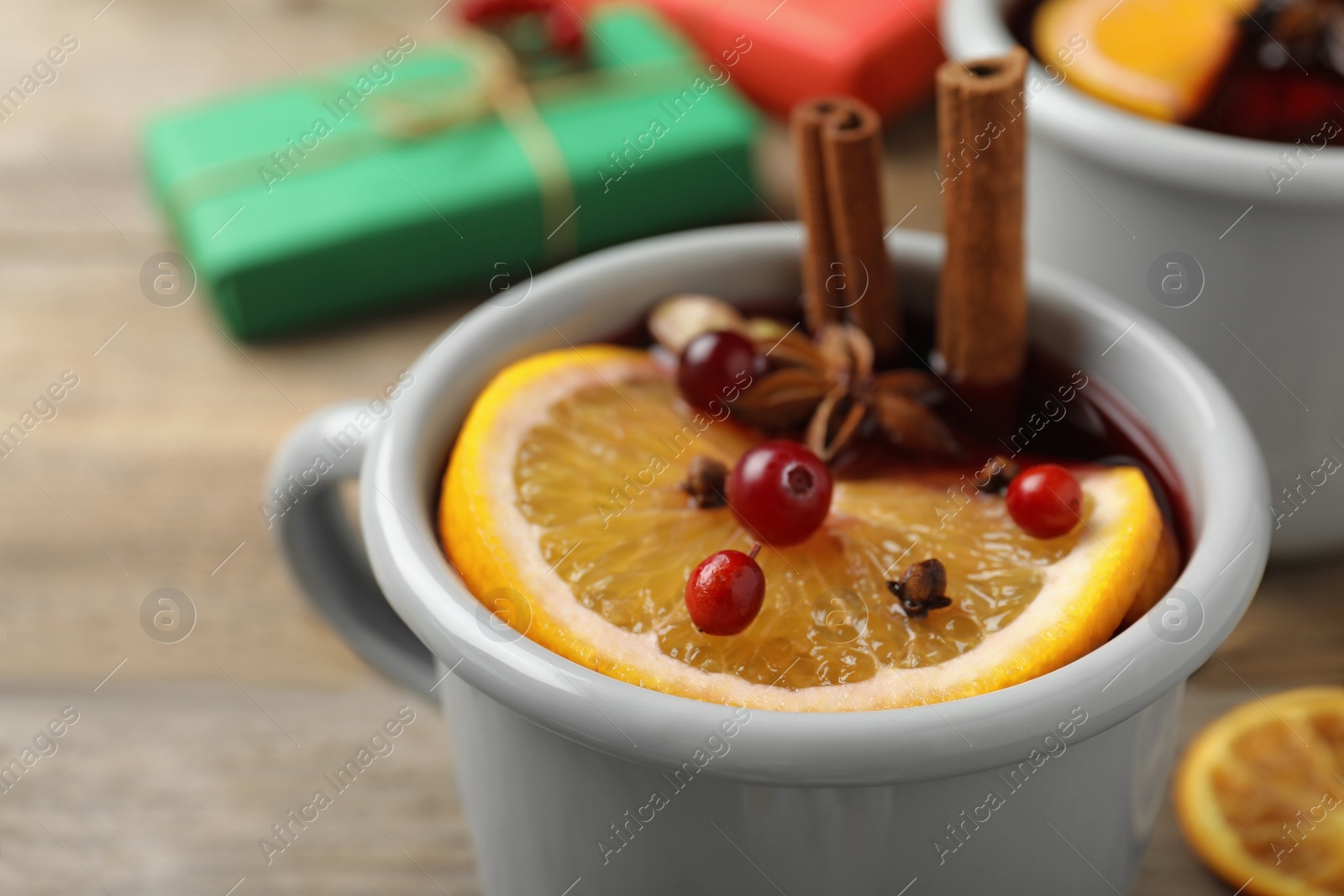 Photo of Cup with tasty mulled wine on table, closeup