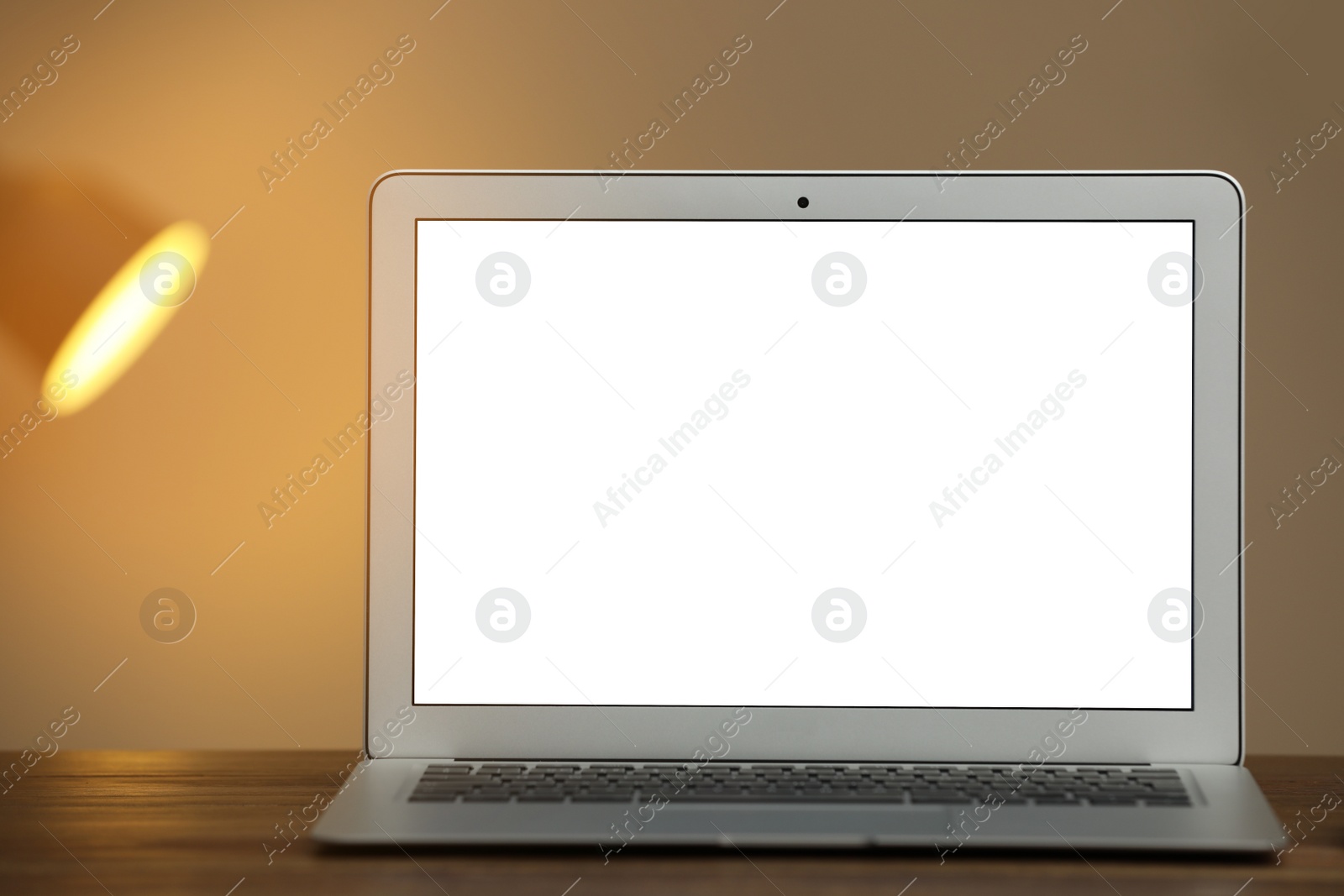 Photo of Laptop with blank screen on table indoors. Space for text