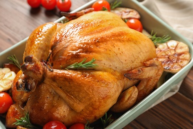 Cooked turkey with vegetables and rosemary in dish on table, closeup