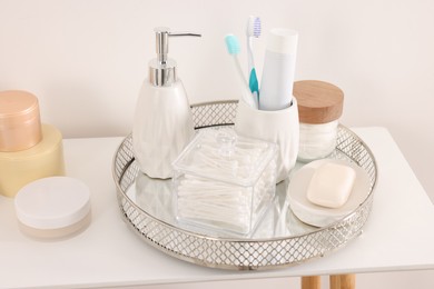 Photo of Different bath accessories and personal care products on table near white wall