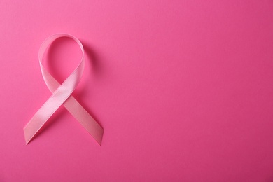 Photo of Pink ribbon and space for text on color background, top view. Breast cancer awareness concept