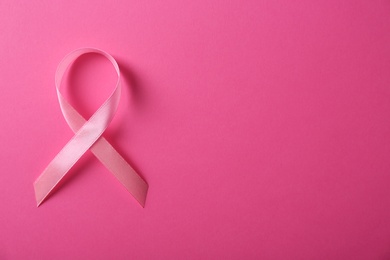 Pink ribbon and space for text on color background, top view. Breast cancer awareness concept