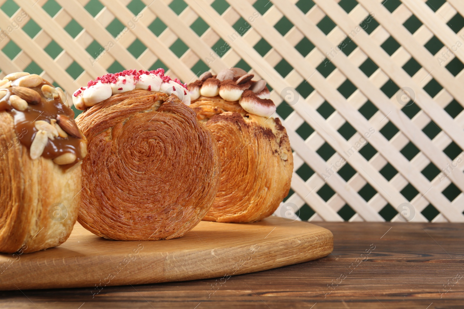 Photo of Crunchy round croissants on wooden table, space for text. Tasty puff pastry