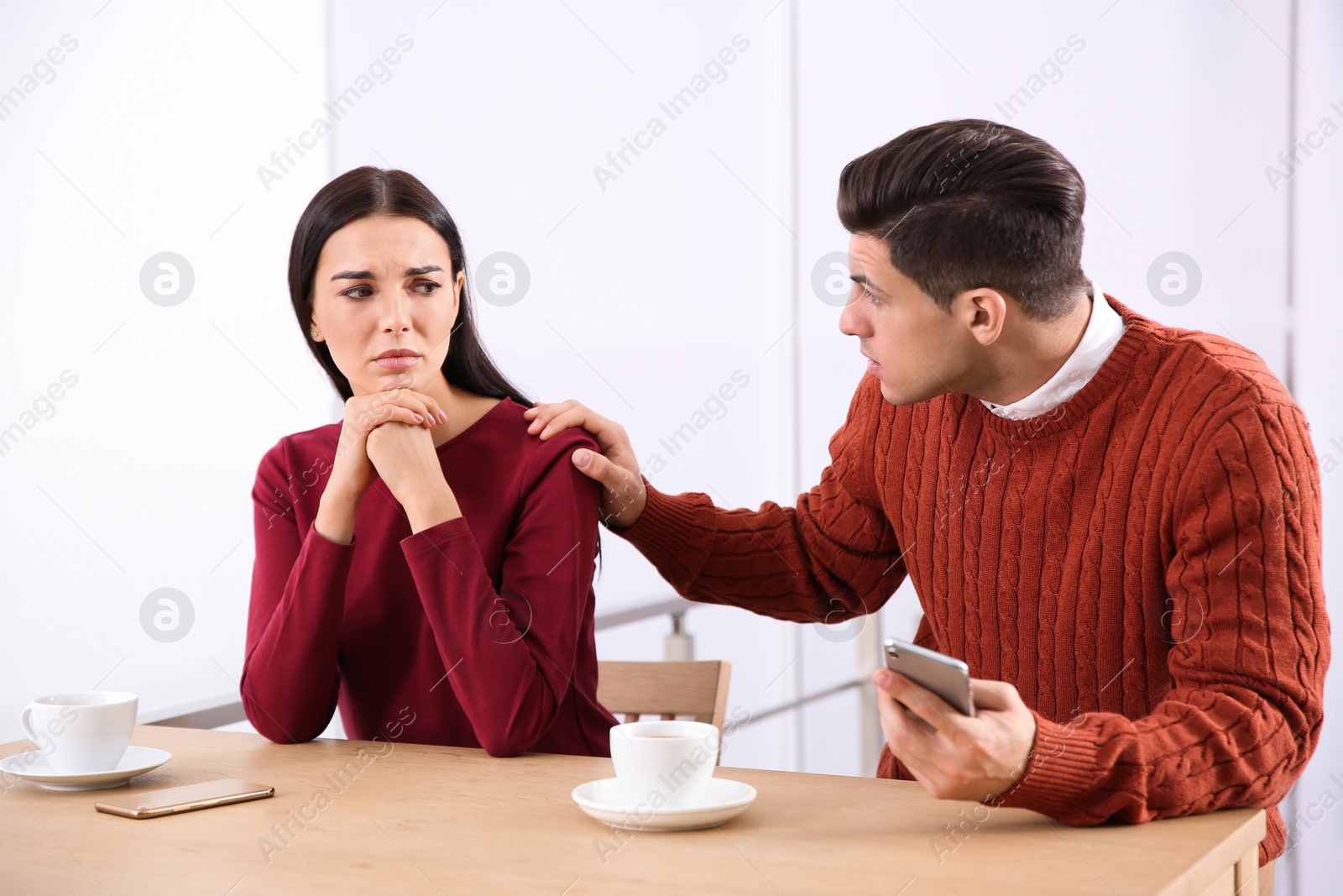Photo of Unhappy couple with relationship problems at table in cafe