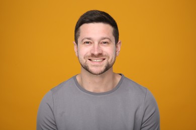 Photo of Portrait of handsome man on orange background