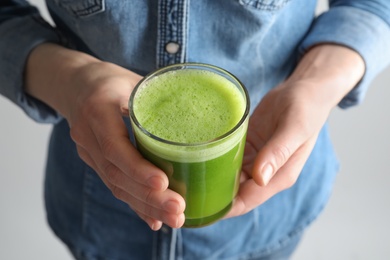 Photo of Woman holding glass with delicious detox juice, closeup