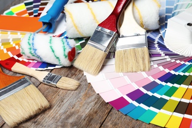 Photo of Set of decorator's tools on wooden background, closeup