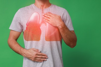 Image of Man holding hands near chest with illustration of lungs on green background, closeup