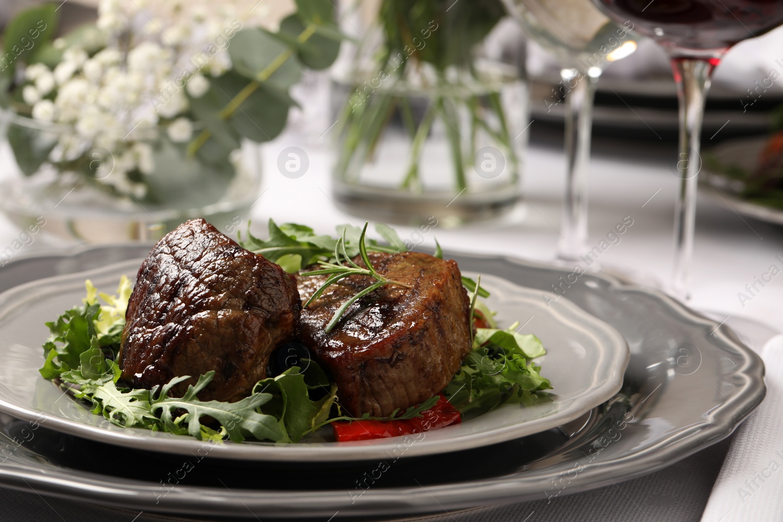 Photo of Delicious grilled meat with vegetables served on table in restaurant