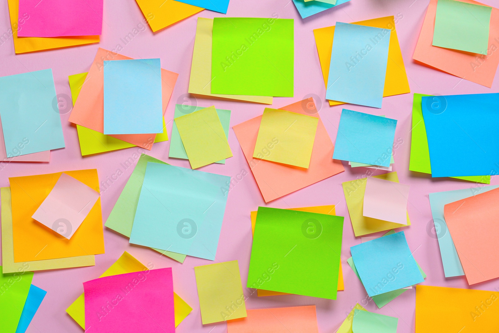 Photo of Blank colorful sticky notes on pink background, flat lay