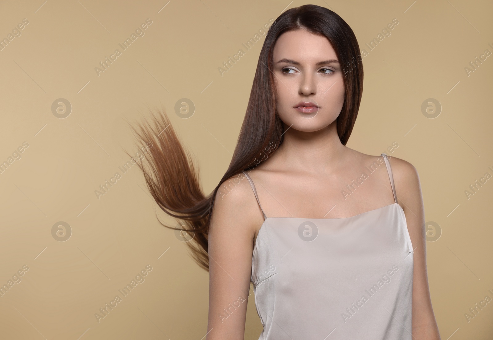 Photo of Portrait of beautiful young woman with healthy strong hair on beige background