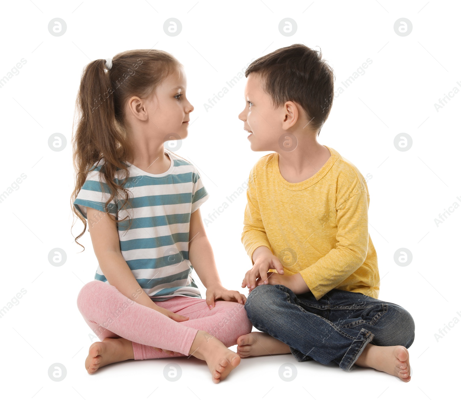 Photo of Cute little boy and girl sitting on white background