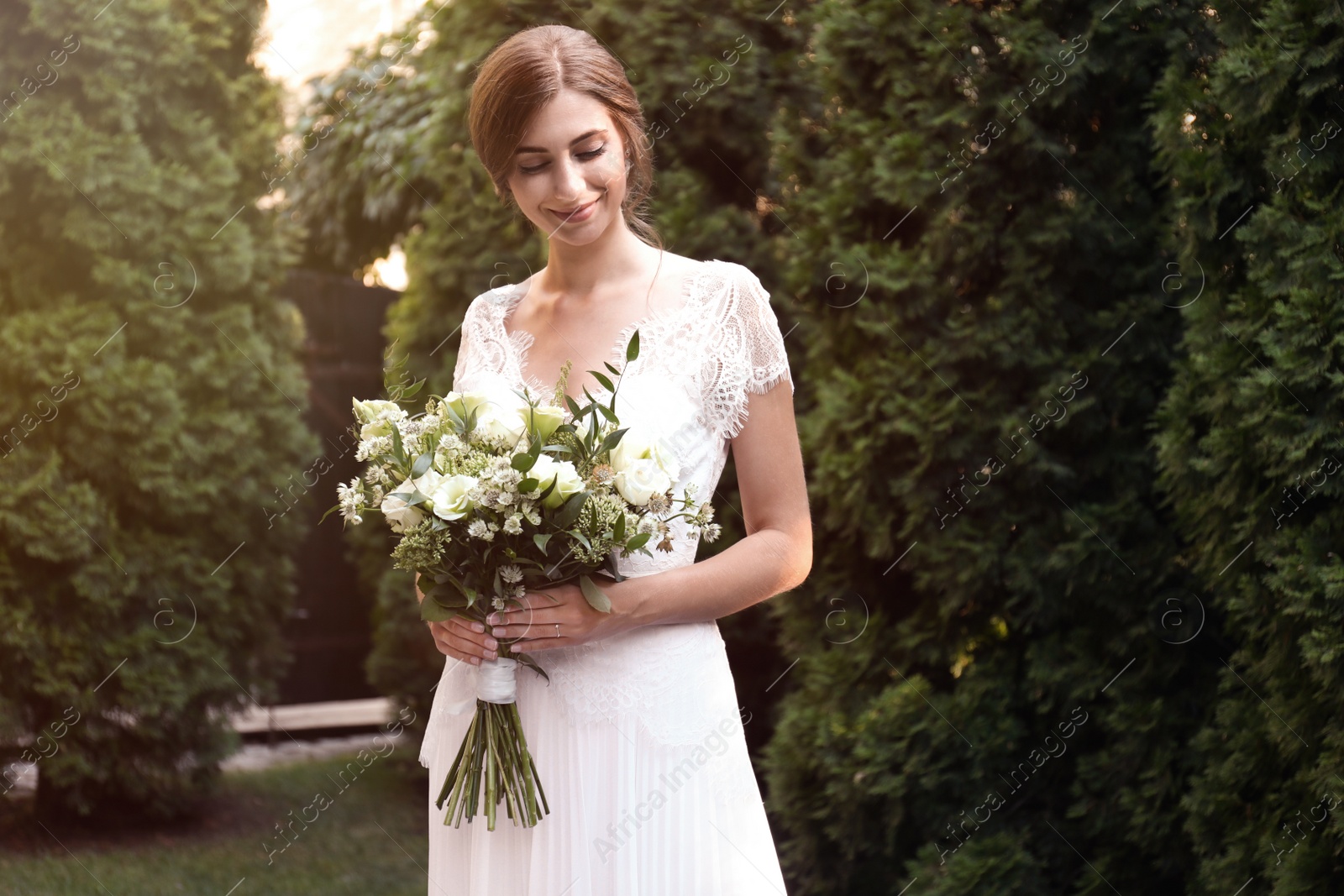 Photo of Gorgeous bride in beautiful wedding dress with bouquet outdoors