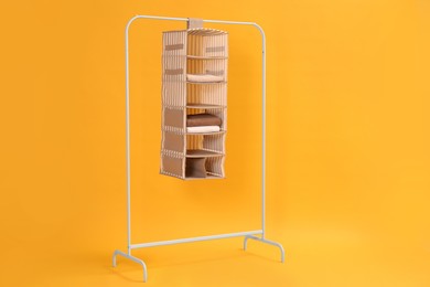 Foldable organizer on rack against yellow background