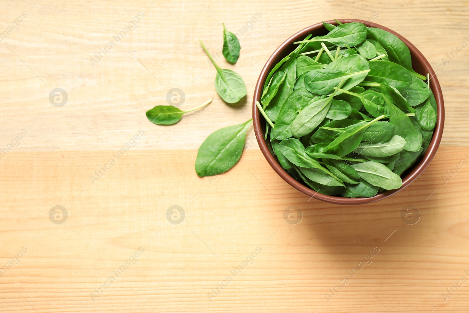 Photo of Fresh green healthy spinach on wooden table, flat lay. Space for text