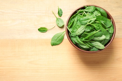 Photo of Fresh green healthy spinach on wooden table, flat lay. Space for text