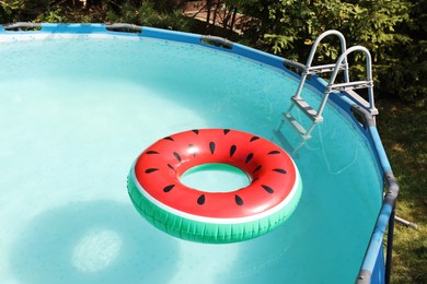 Photo of Inflatable ring floating on water in above ground swimming pool outdoors