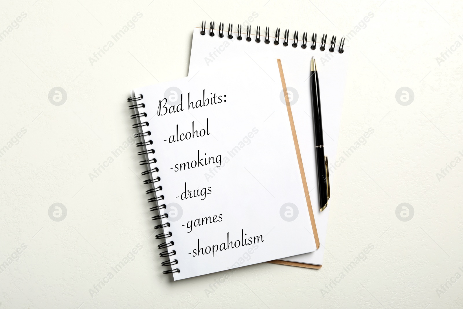 Image of Notebook with list of bad habits on white table, flat lay