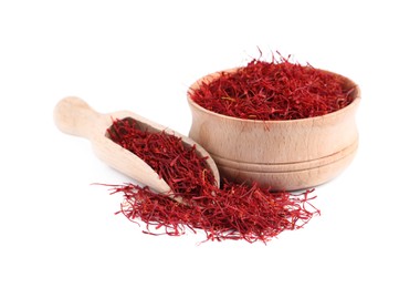 Photo of Dried saffron, wooden bowl and scoop on white background