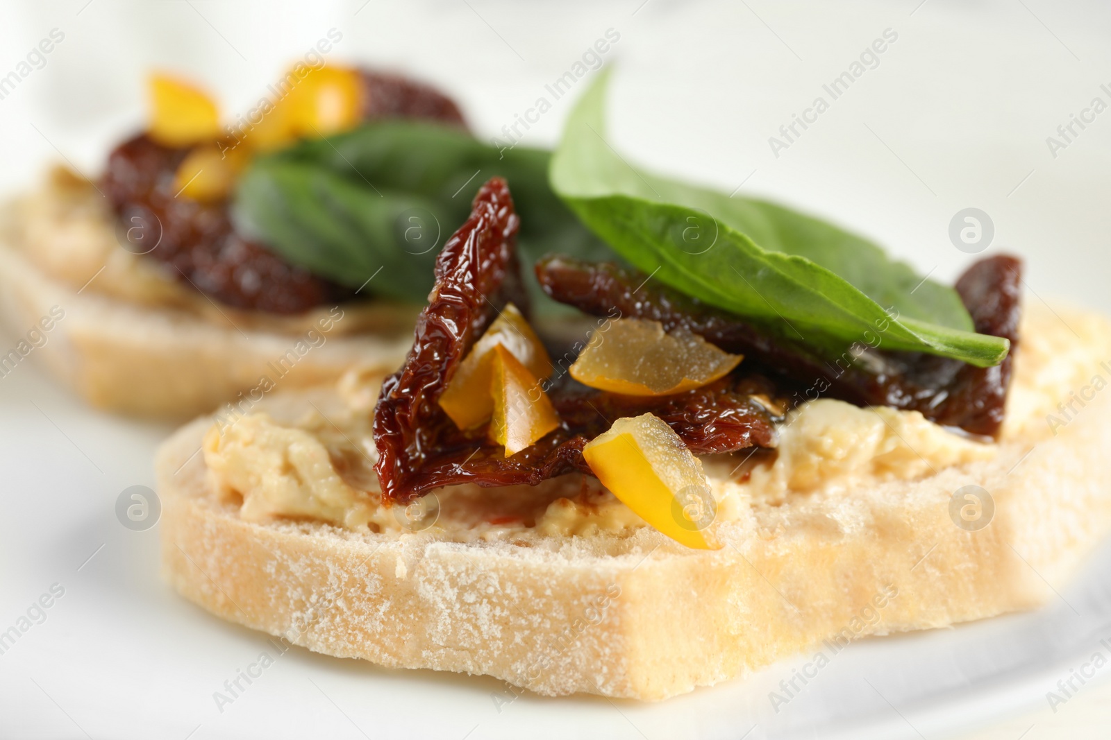 Photo of Delicious tomato bruschettas on white plate, closeup