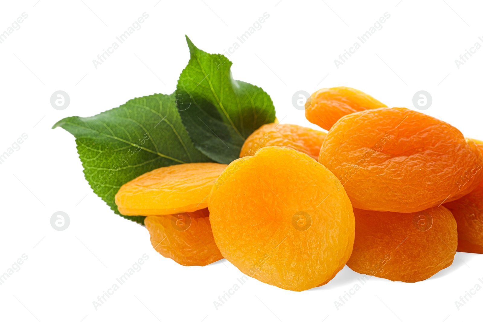 Photo of Pile of tasty apricots and green leaves on white background. Dried fruits