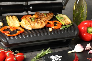 Photo of Electric grill with different products on grey table