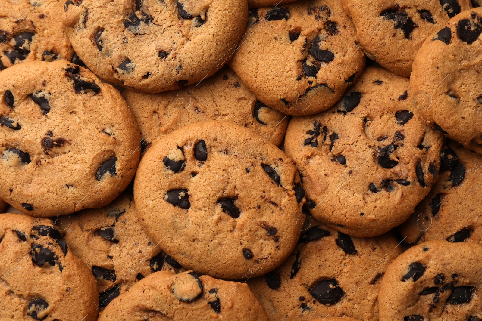 Photo of Delicious chocolate chip cookies as background, top view