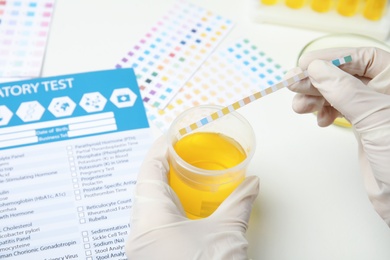Photo of Doctor doing urine analysis at white table