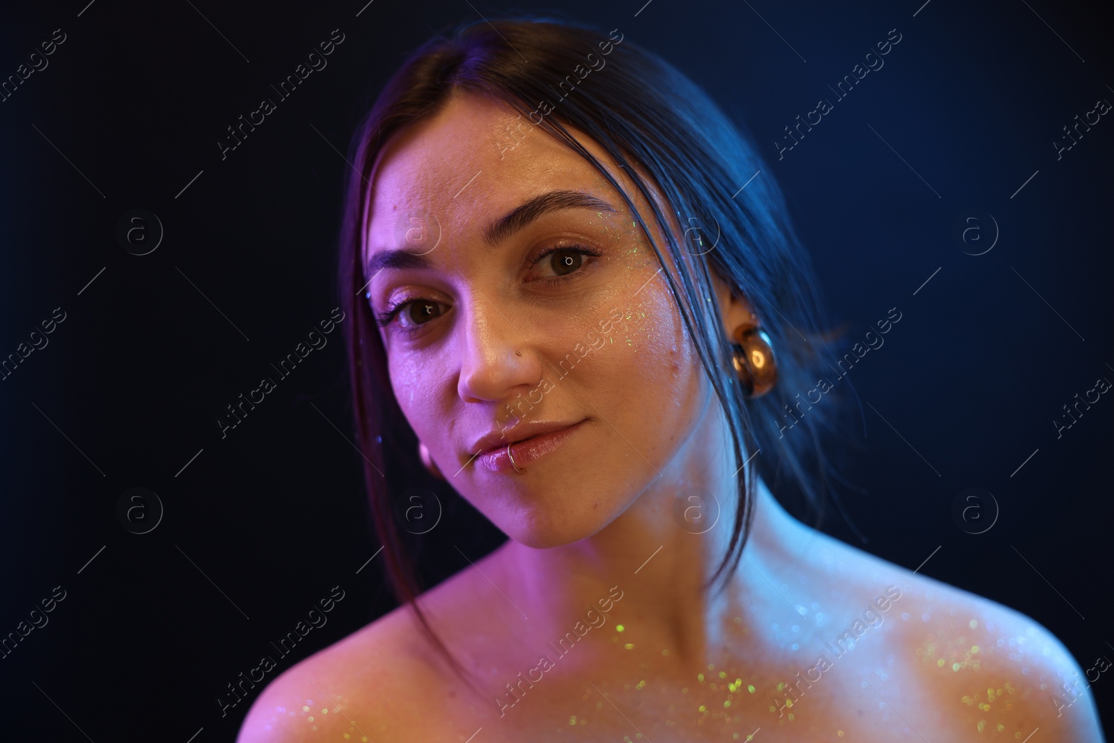 Photo of Portrait of beautiful woman on dark background in neon lights