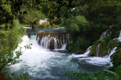 Picturesque view of beautiful waterfall and rocks outdoors