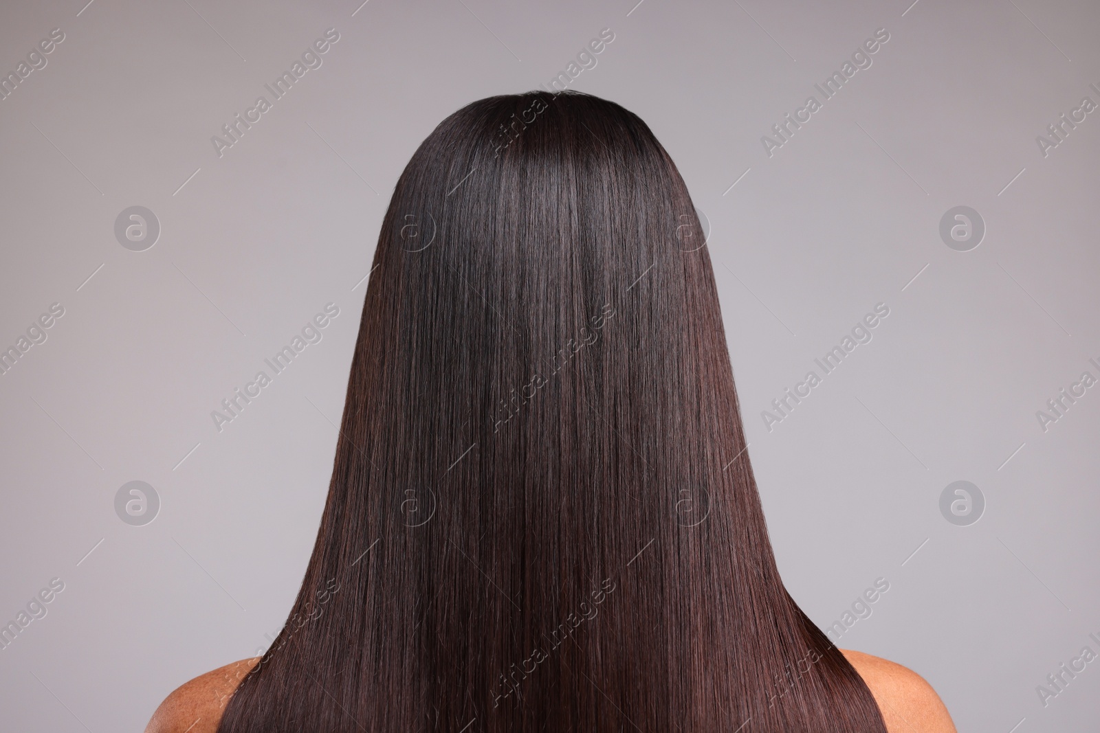 Photo of Woman with healthy hair after treatment on light gray background, back view