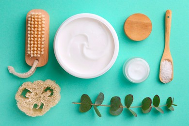 Jars of cream, body care products and eucalyptus branch on turquoise background, flat lay