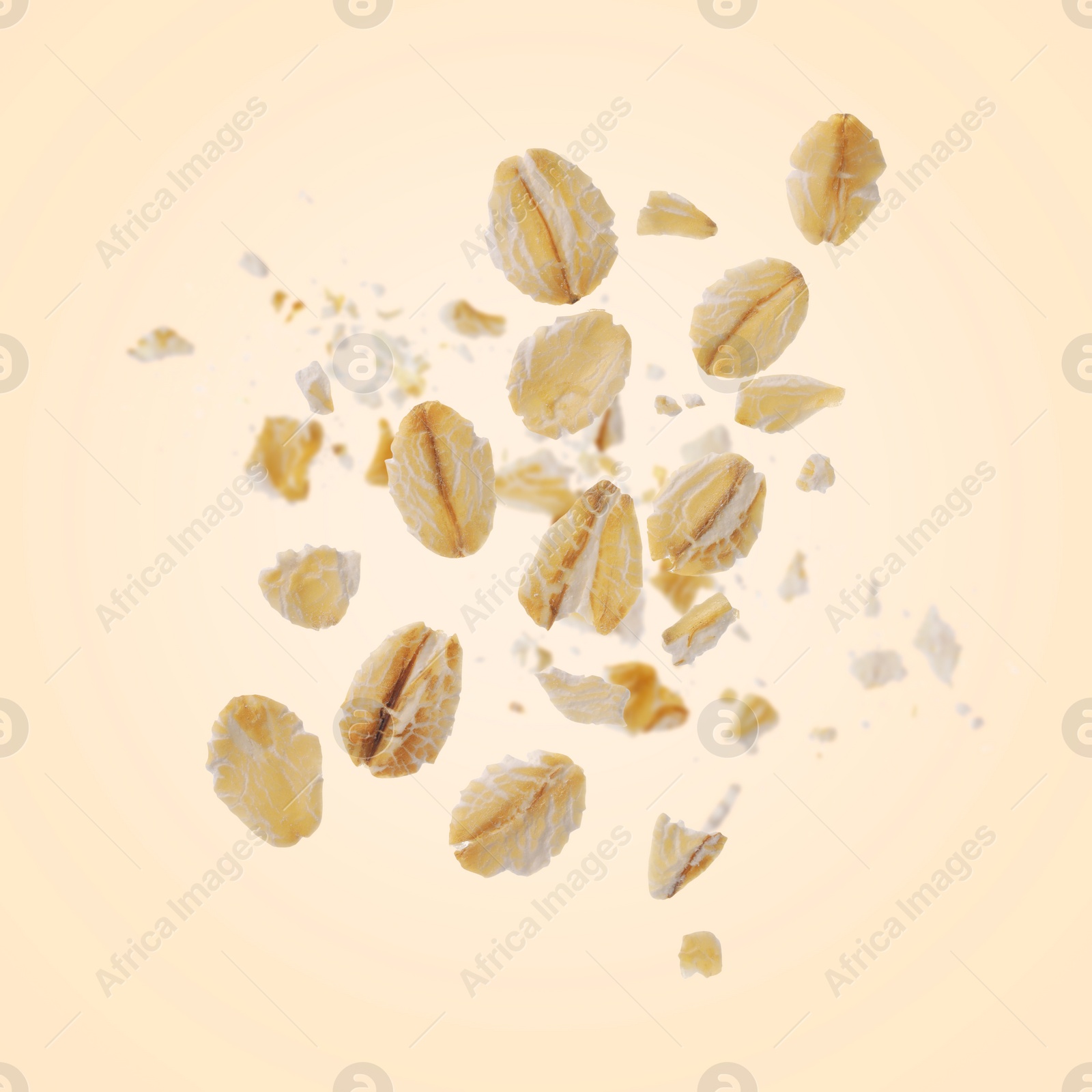 Image of Rolled oat flakes falling on beige background