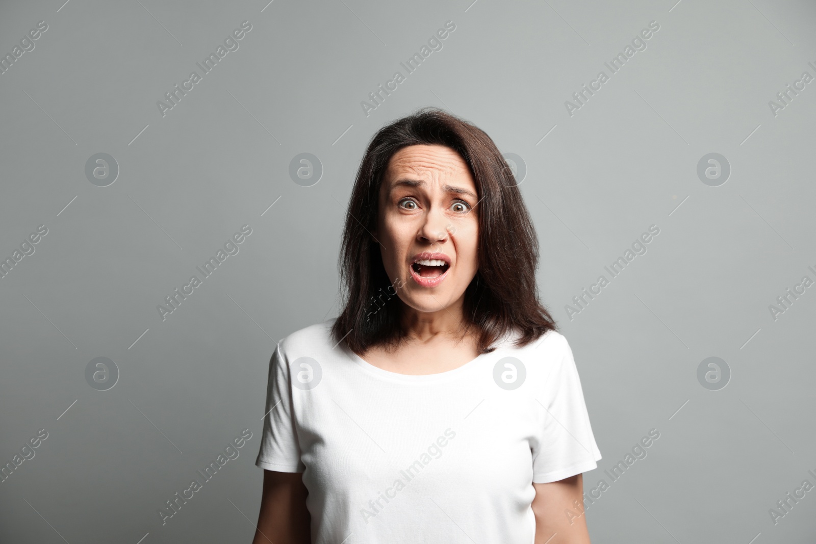 Photo of Mature woman feeling fear on grey background