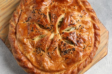 Photo of Tasty homemade pie with filling on light grey table, top view