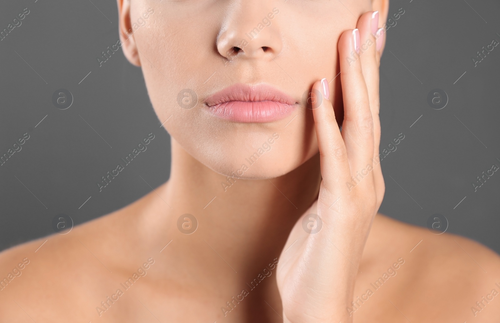 Photo of Closeup view of beautiful young woman on grey background. Lips contouring, skin care and cosmetic surgery concept