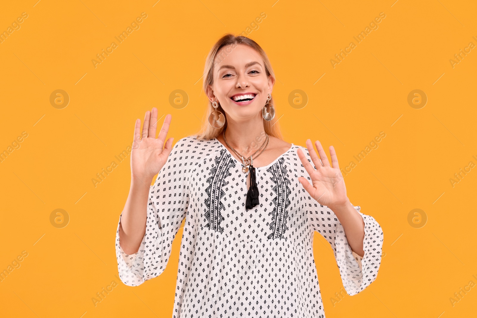 Photo of Portrait of smiling hippie woman on yellow background