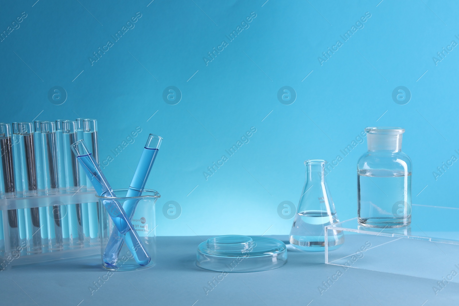 Photo of Laboratory analysis. Different glassware on table against light blue background