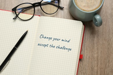 Image of Motivational quote Change Your Mind Accept The Challenge written in notebook, eyeglasses and cup of coffee on wooden table, flat lay