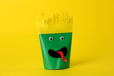 Funny green monster on yellow background. Halloween decoration