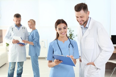 Photo of Doctor and medical assistant with colleagues in clinic. Health care service