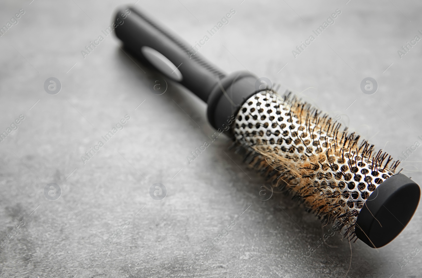 Photo of Brush with lost hair on gray table. Alopecia problem