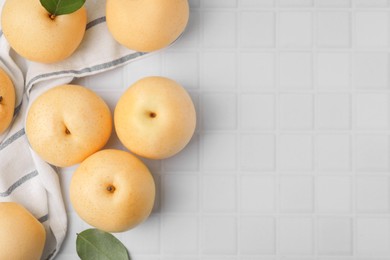 Photo of Delicious apple pears on white tiled table, flat lay. Space for text
