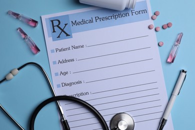 Medical prescription form, stethoscope, ampoules and pills on light blue background