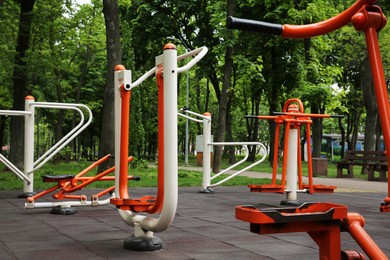Empty outdoor gym with air walker, push up bars, rowing machine and double abductor