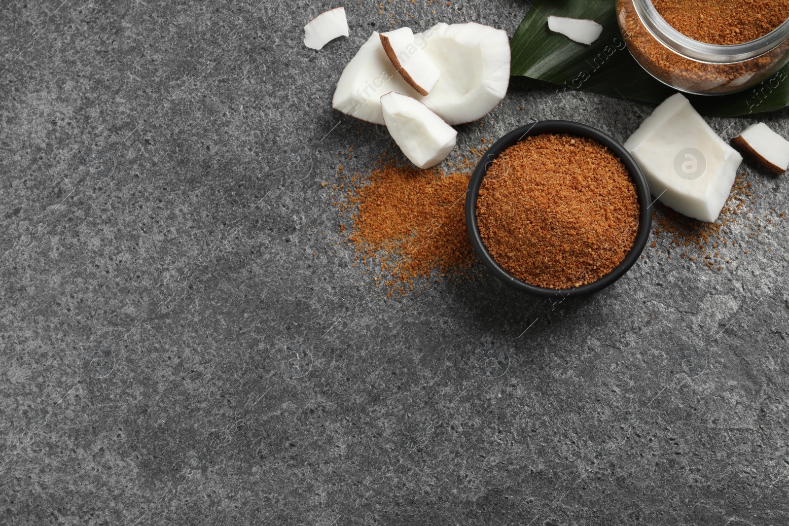 Photo of Flat lay composition with natural coconut sugar on grey table, space for text