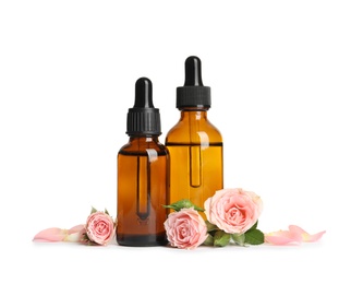 Photo of Bottles of rose essential oil and flowers isolated on white